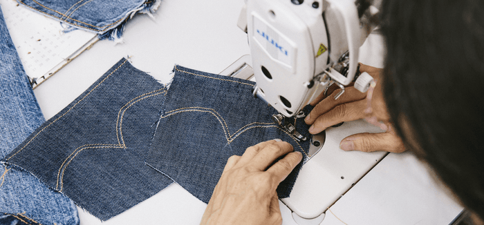 A woman sewing jeans 